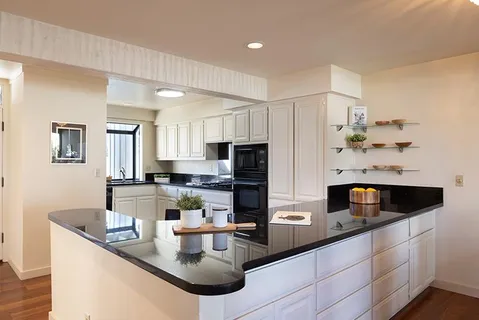 a kitchen with stainless steel appliances granite countertop a sink and a refrigerator