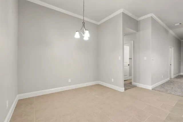 an empty room with chandelier fan