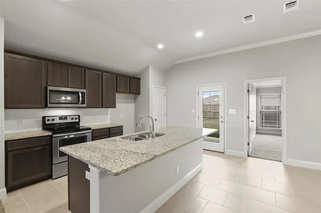 a kitchen with stainless steel appliances granite countertop a sink stove and refrigerator
