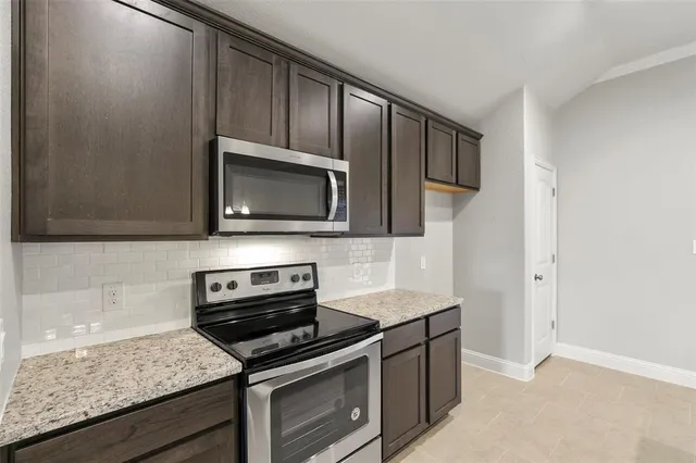 a kitchen with stainless steel appliances granite countertop a stove microwave and sink