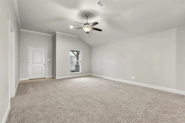 an empty room with chandelier fan and windows