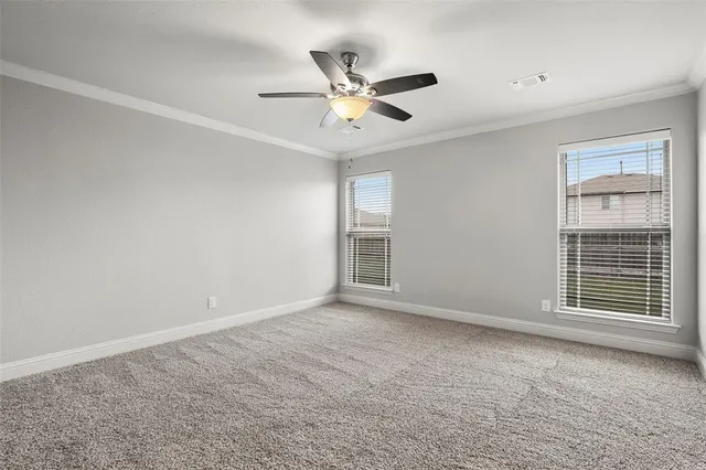 a view of an empty room with a ceiling fan and window