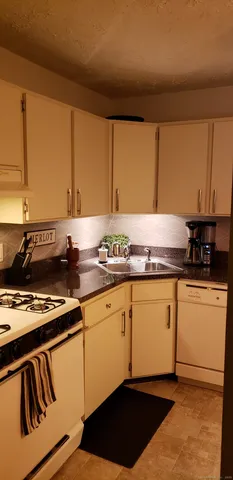 a kitchen with granite countertop cabinets and black appliances