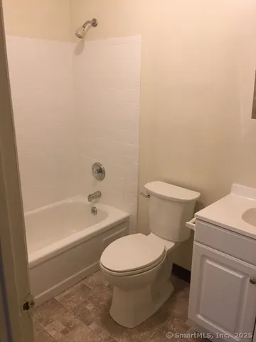 a white toilet sitting next to a bath tub