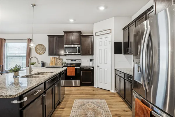 a open kitchen with stainless steel appliances granite countertop a sink stove and refrigerator