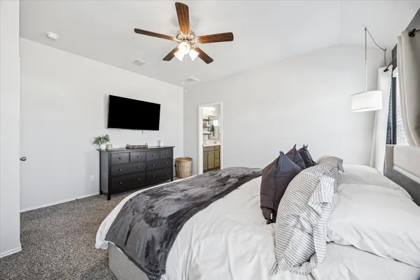 a bed room with a bed and a ceiling fan