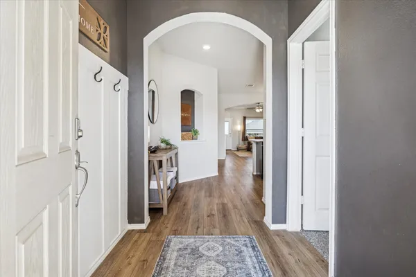 a hallway with wooden floor fireplace and living room