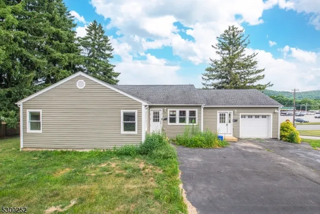 a view of a house next to a yard and large tree