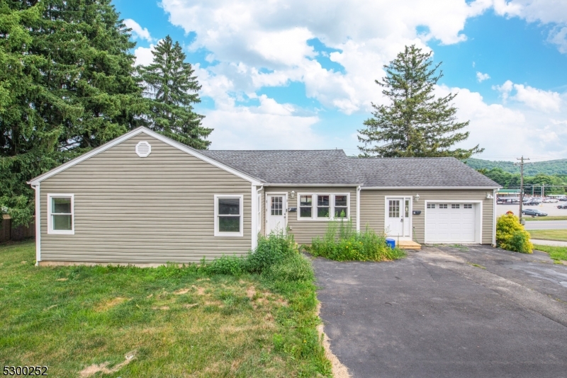 a view of a house next to a yard and large tree