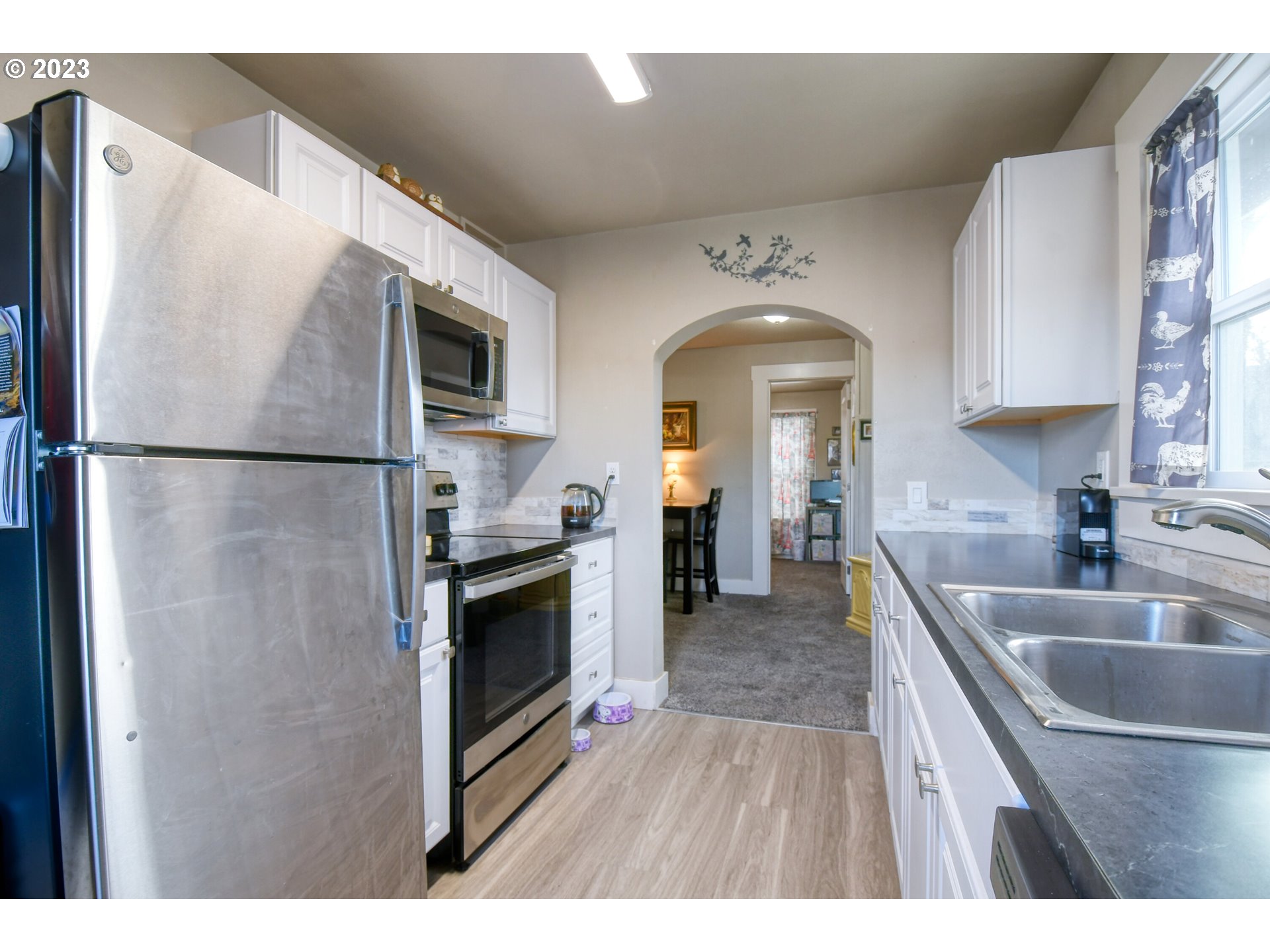 207 Southwest Isaac Avenue Pendleton, OR 97801 - Photo 15 of 32 a kitchen with kitchen island a counter top space a sink and a refrigerator