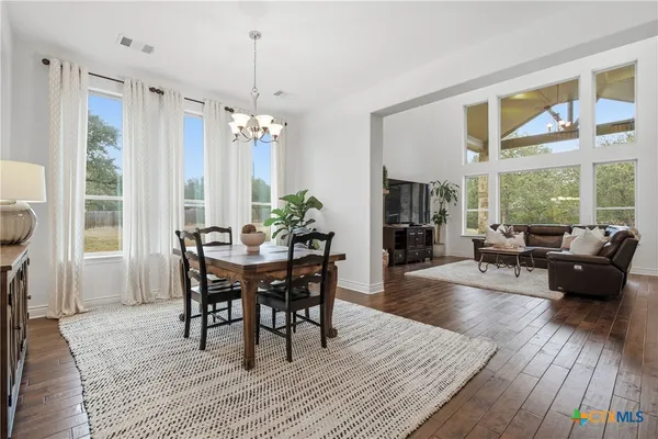 a living room with furniture dining table and a large window