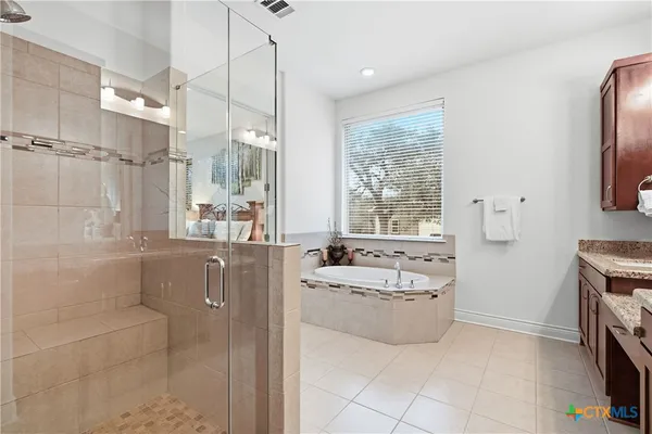a spacious bathroom with a tub sink a mirror and a shower