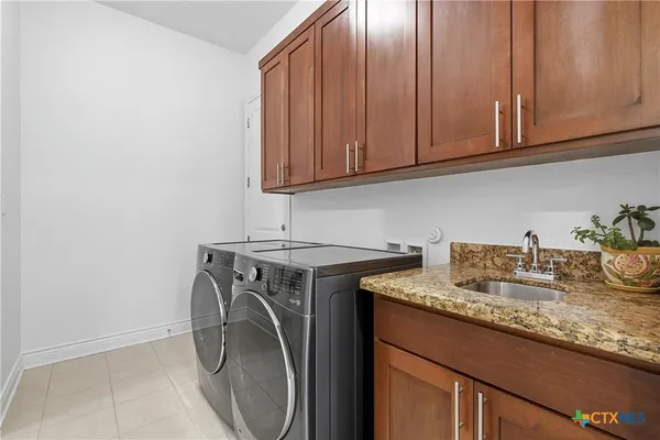 a utility room with granite countertop cabinets washer and dryer
