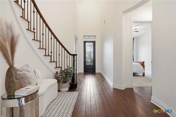 a view of a hallway with wooden floor and stairs