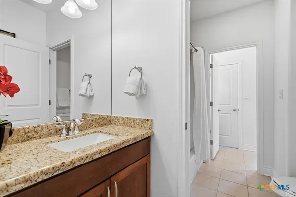 a bathroom with a granite countertop sink and a mirror