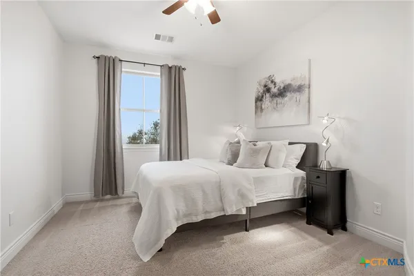 a large bed sitting in a bedroom next to a window