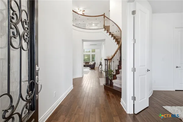 a view of a hallway with wooden floor and staircase
