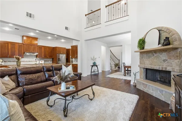 a living room with furniture a fireplace and a kitchen view