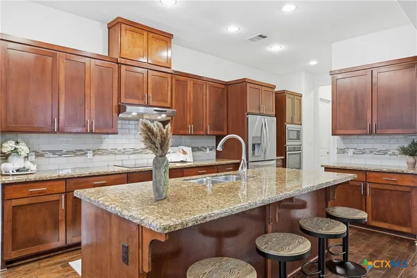 a kitchen with stainless steel appliances granite countertop a sink counter space and cabinets