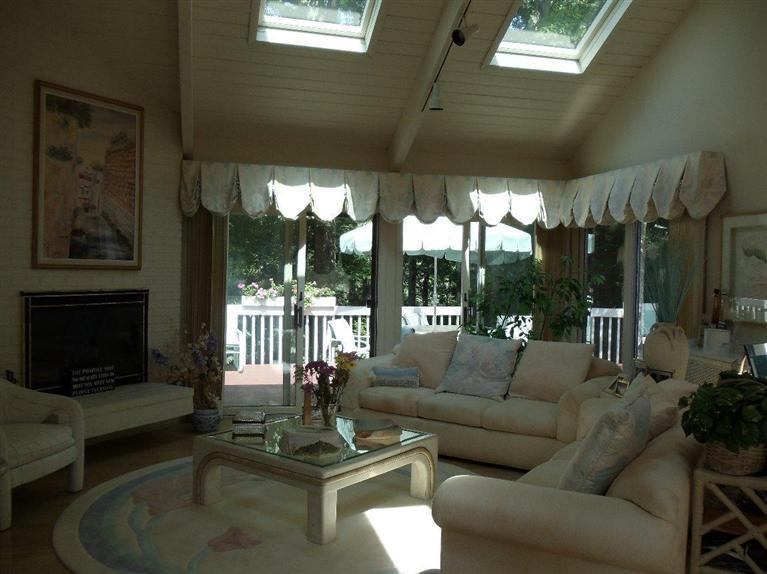 116 Fells Pond Road Mashpee, MA 02649 - Photo 8 of 21 a living room with furniture a flat screen tv and a floor to ceiling window