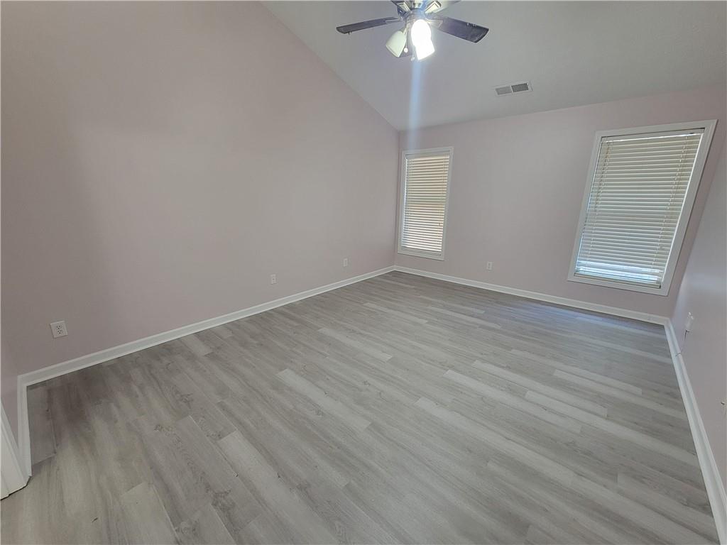 2213 Carlton Chase Road Dacula, GA 30019 - Photo 13 of 30 an empty room with wooden floor chandelier fan and window