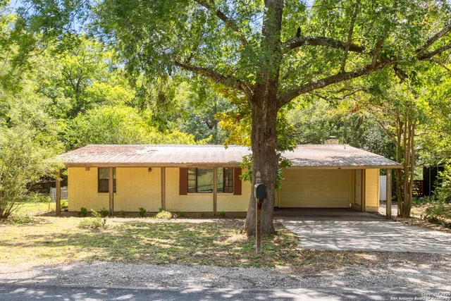a view of a house with a yard and tree