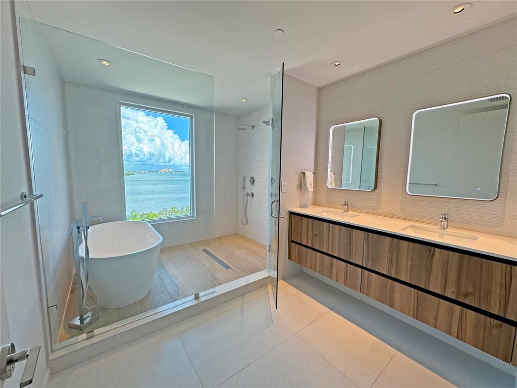 1020 Sunset Point Road, Unit 609 Clearwater, FL 33755 - Photo 4 of 20 a bathroom with a granite countertop sink and a mirror