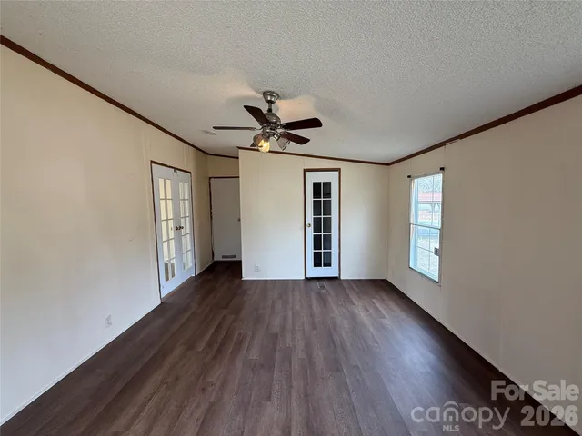 a view of a livingroom with wooden floor and a ceiling fan