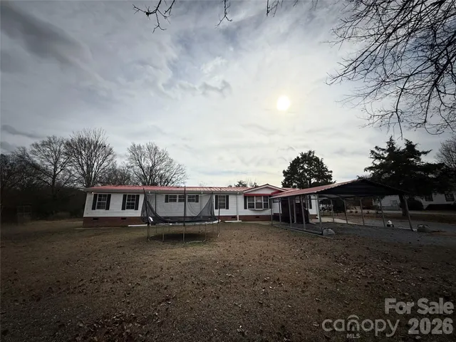 a view of a house with a yard and sitting area