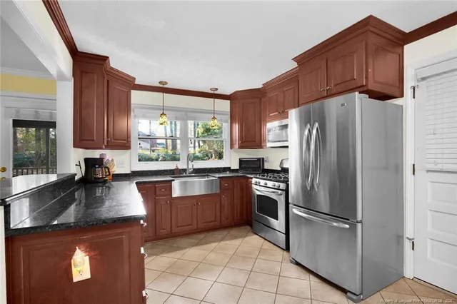 a kitchen with granite countertop a refrigerator and a sink