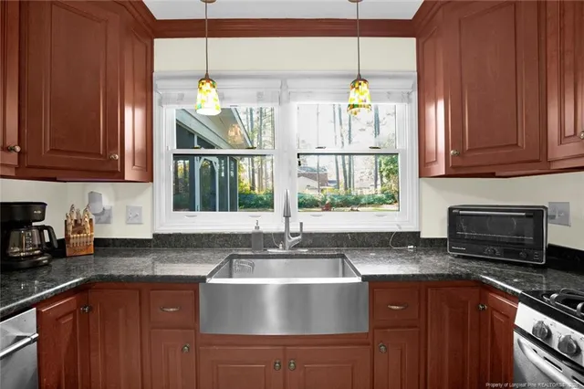 a kitchen with kitchen island granite countertop a sink window and cabinets