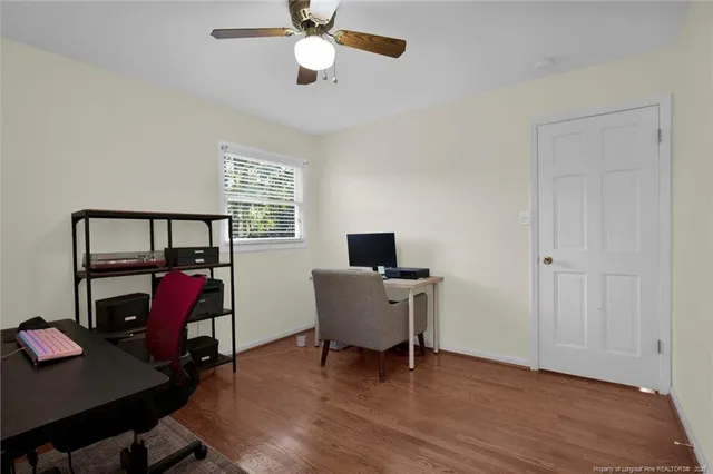 a view of a workspace with furniture and wooden floor