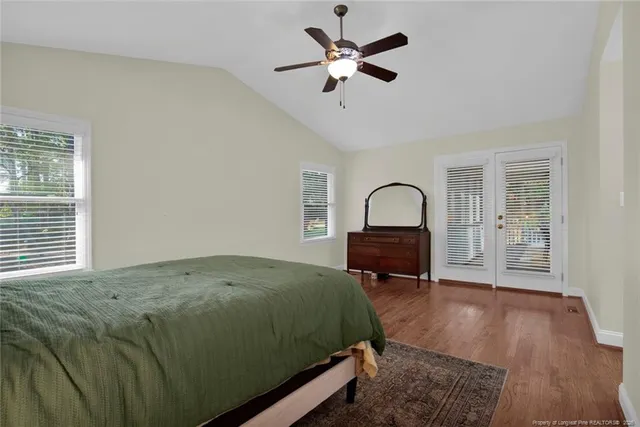 a bedroom with a bed large window and a table