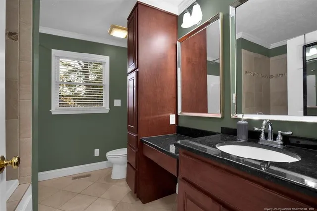 a bathroom with a granite countertop sink toilet and mirror
