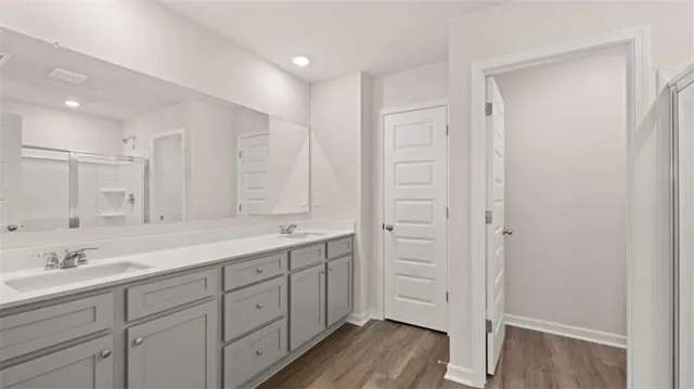 a spacious bathroom with a double vanity sink a mirror and a bathtub