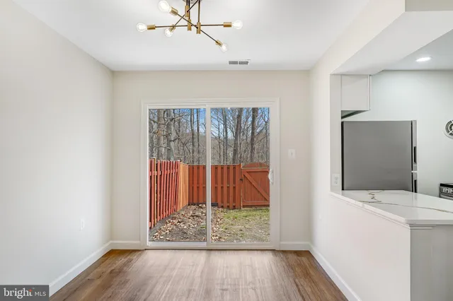 a view of hallway with a mirror and wooden floor