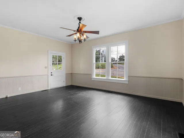 a view of a livingroom with wooden floor and a ceiling fan