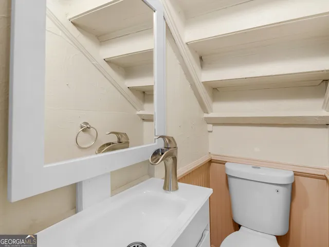 a bathroom with a toilet sink and mirror