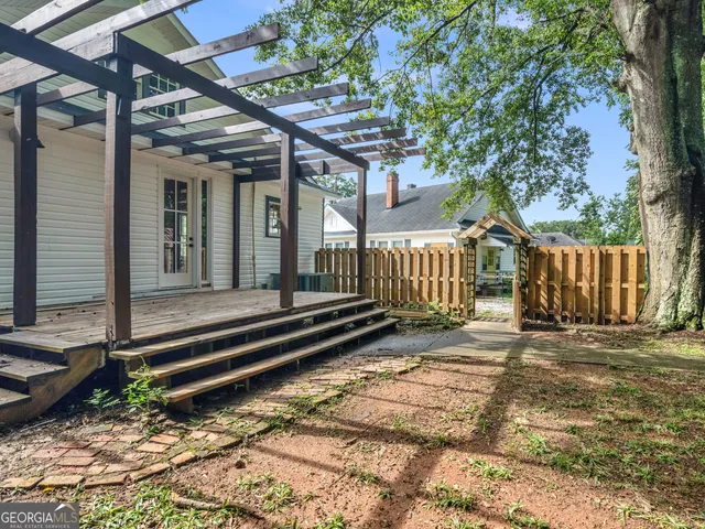 a porch with a bench next to a yard