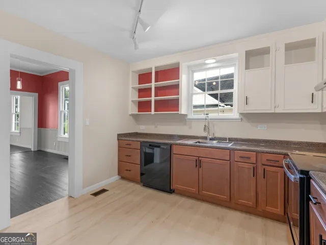 a kitchen with stainless steel appliances granite countertop a sink and cabinets with wooden floor