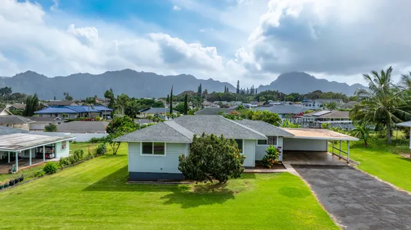 a aerial view of a house next to a big yard and large trees
