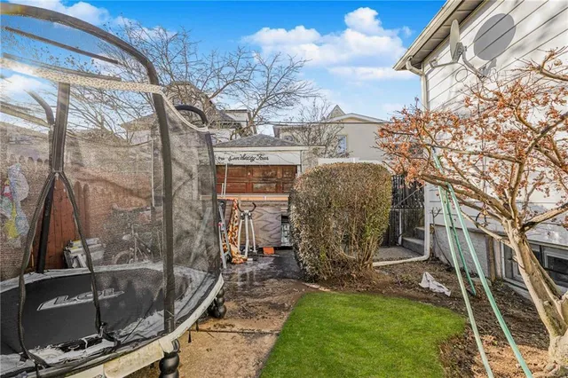 a view of a house with backyard and a tree