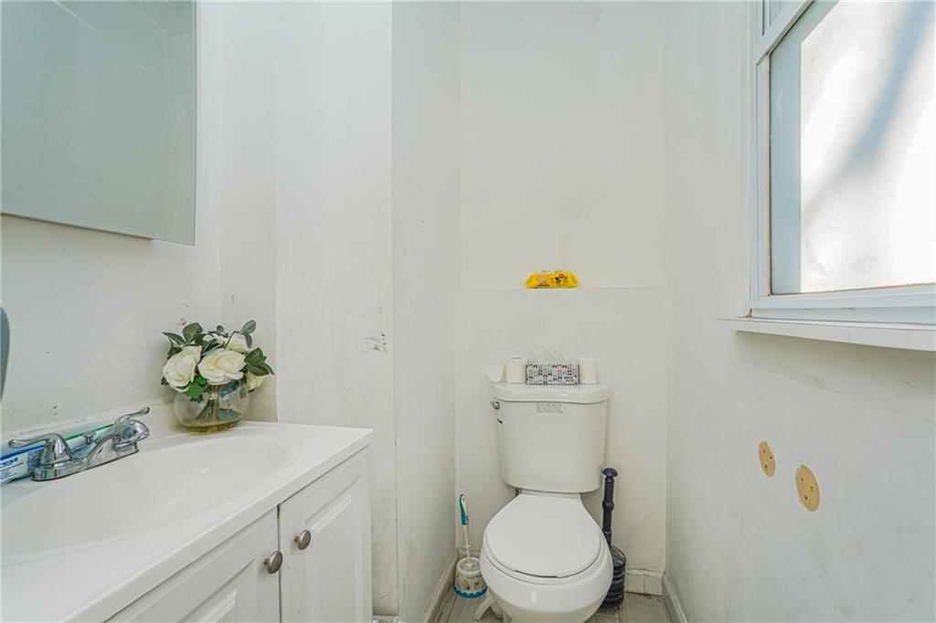 1764 East 24th Street Brooklyn, NY 11229 - Photo 6 of 16 a bathroom with a sink a toilet and a window