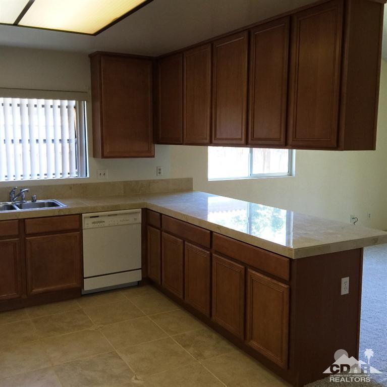 67665 Paletero Road Cathedral City, CA 92234 - Photo 6 of 18 a kitchen with wooden cabinets and sink