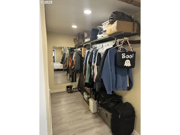 a view of walk in closet with clothes and shoes