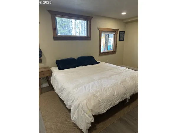 a bed sitting in a spacious bedroom next to a window