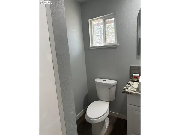 a white toilet sitting next to a small window