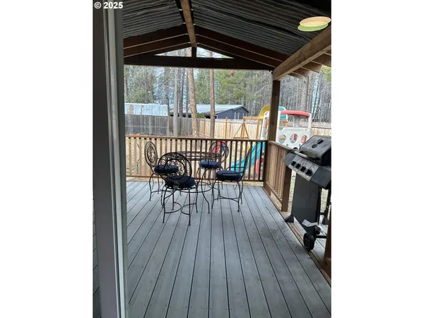 a view of living room kitchen with stainless steel appliances wooden floor and chair