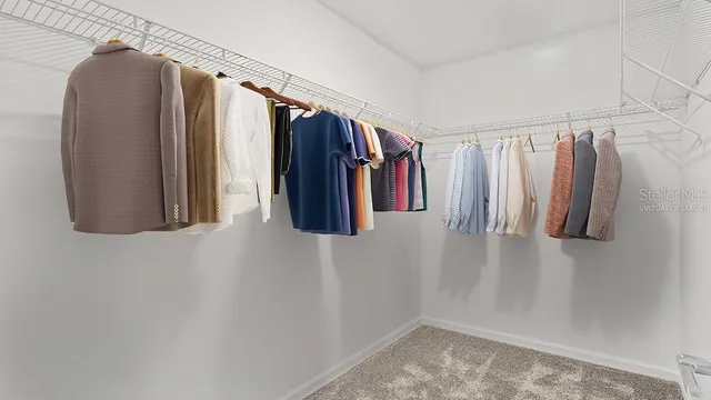 a view of walk in closet with clothes and shoes