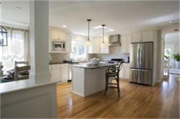 a kitchen with stainless steel appliances granite countertop a refrigerator a sink a stove and a wooden floors
